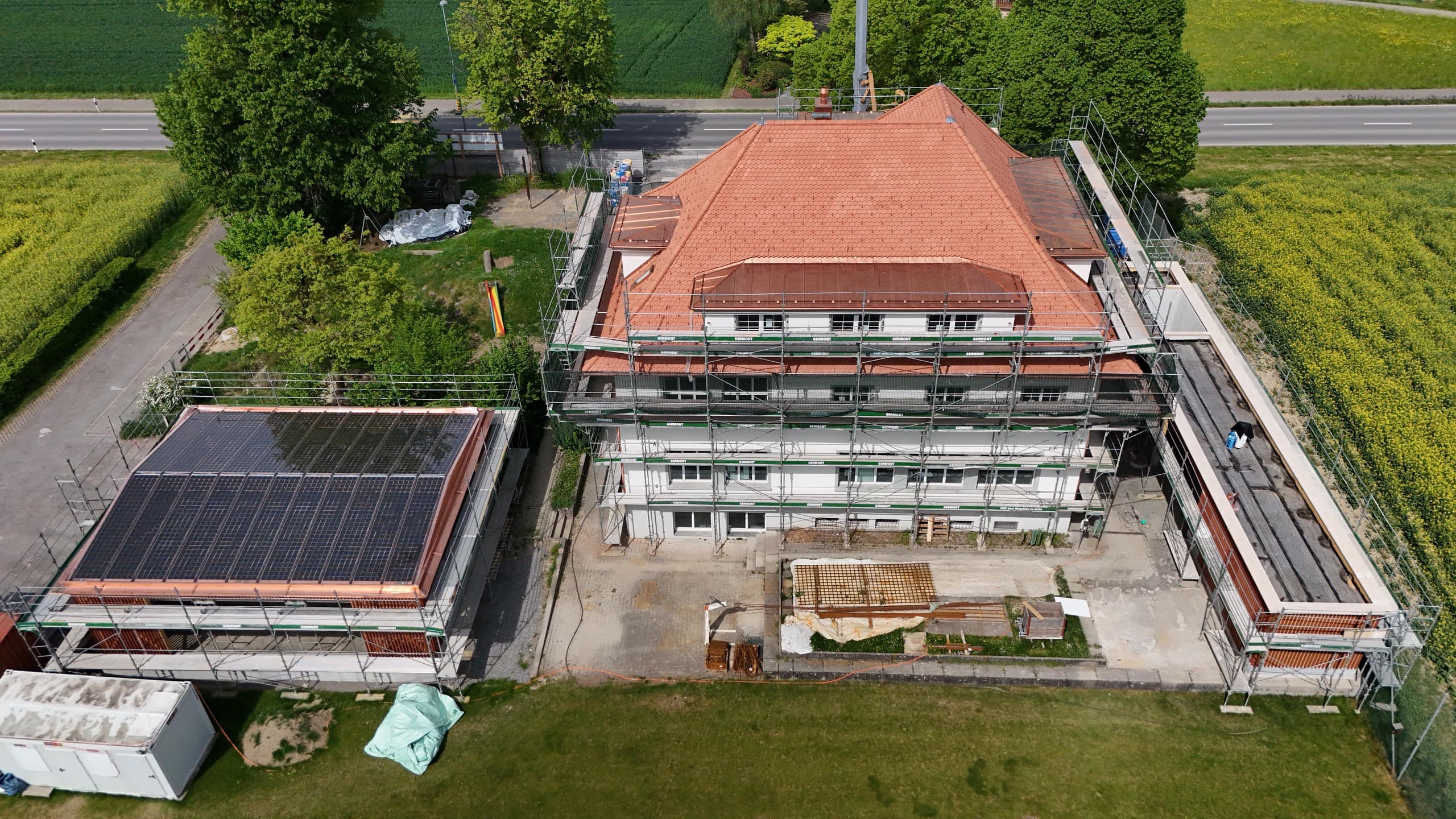 Luftaufnahme des Schulhauses Matten in Hünenberg während der Gesamtsanierung, eingerüstet